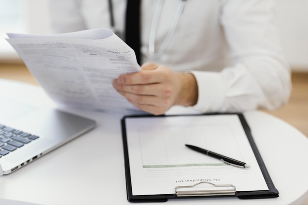 close-up-doctor-holding-medical-records_23-2148868184