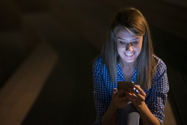 Excited beautiful girl receiving a sms message with good news in