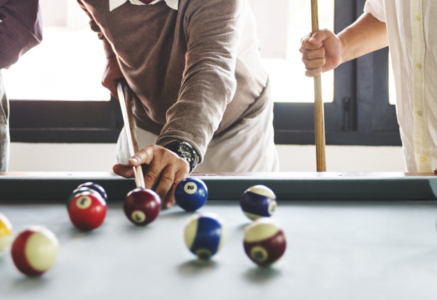 Friends playing pool game together