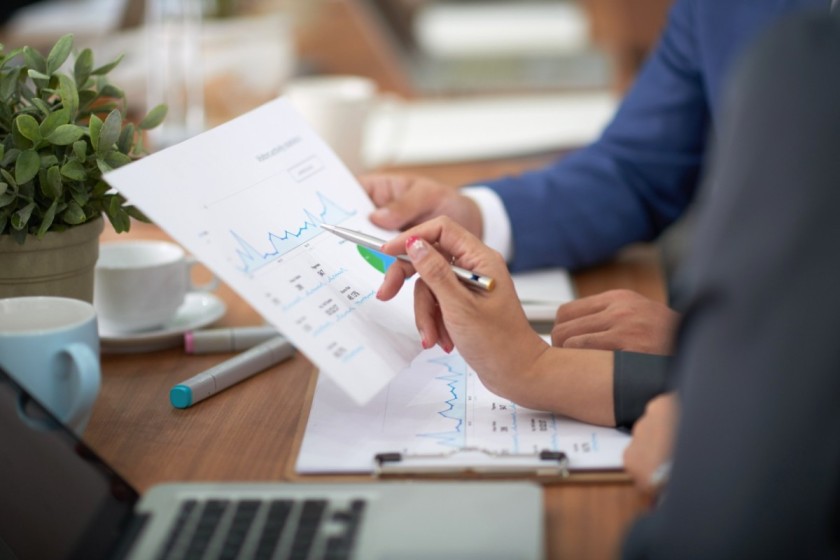 hands-man-woman-business-attire-sitting-desk-office-discussing-graph (1) (1) (1) (1) (1)