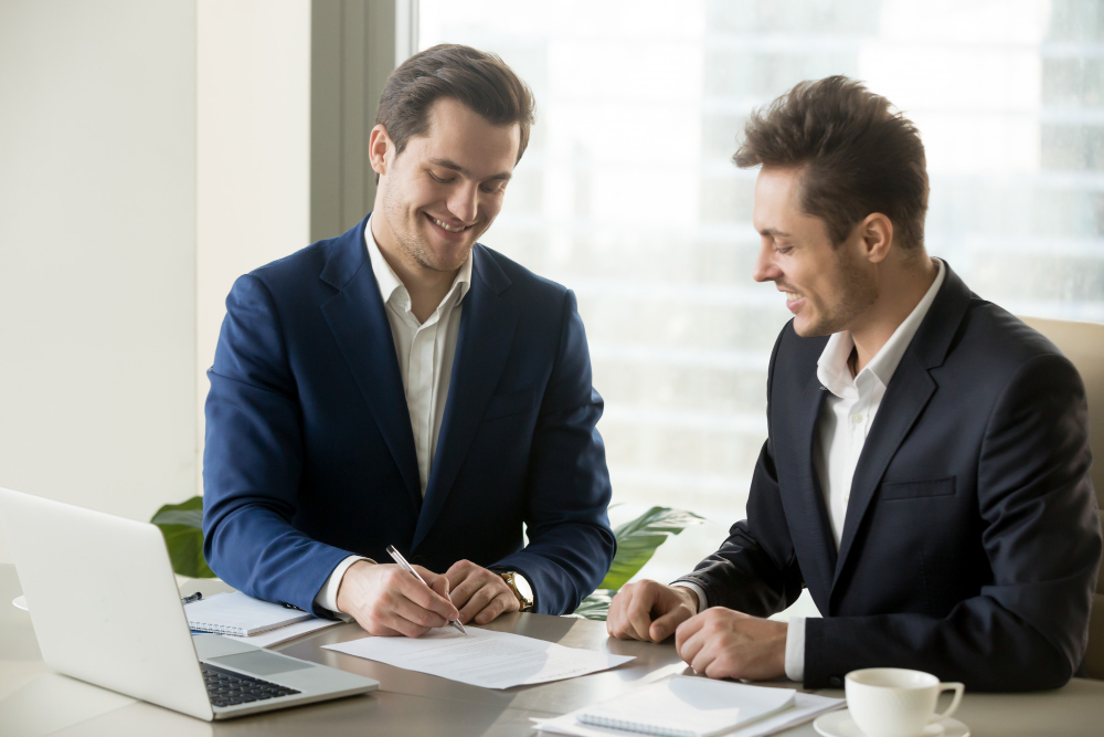 handsome-businessman-signing-contract-with-partner