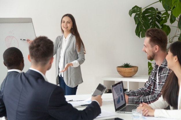 smiling-young-employee-giving-presentation-working-with-flipchart-meeting-room_1163-4622