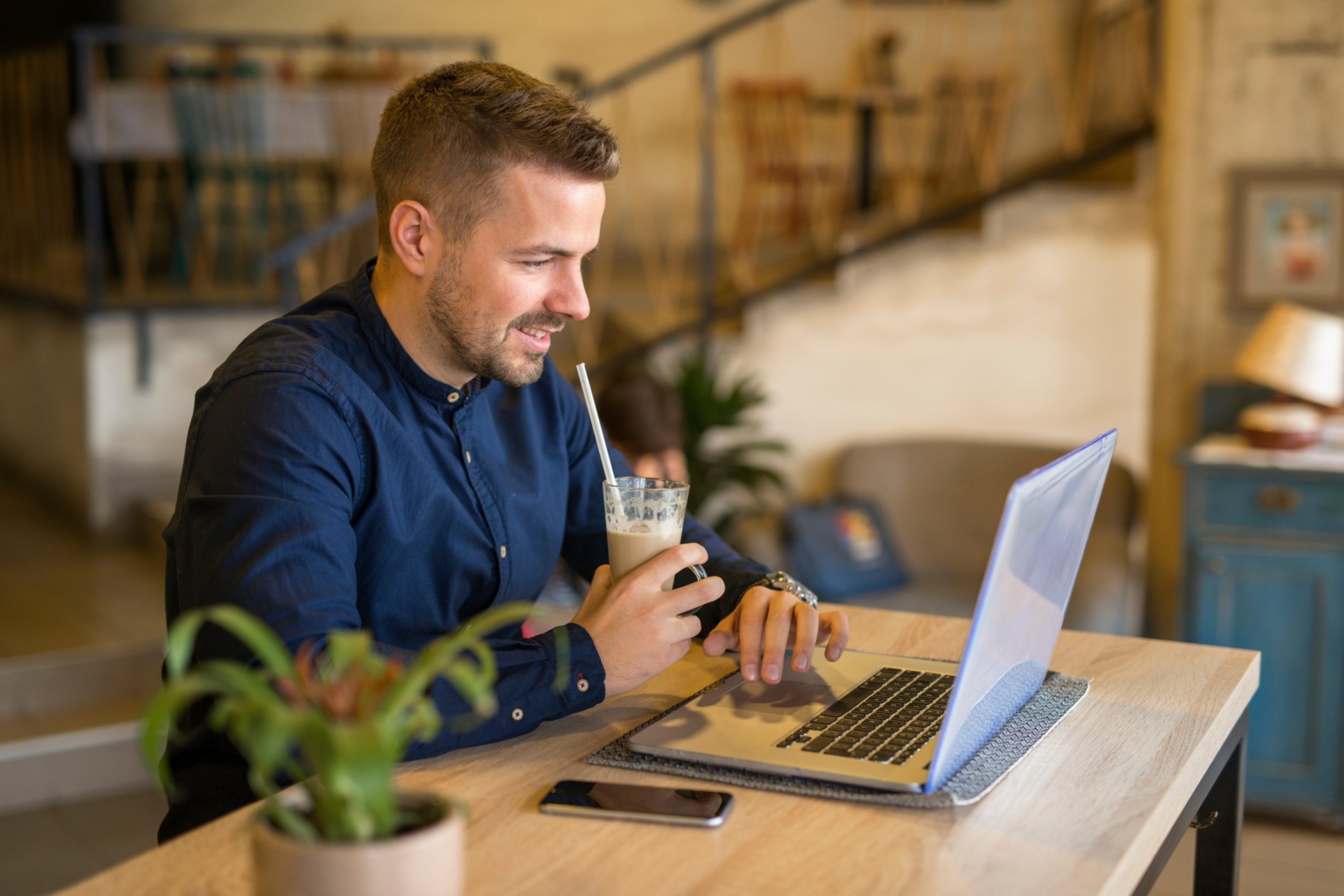 smiling-young-man-working-computer-cozy-cafe-bar-restaurant (1) (1) (1) (1)